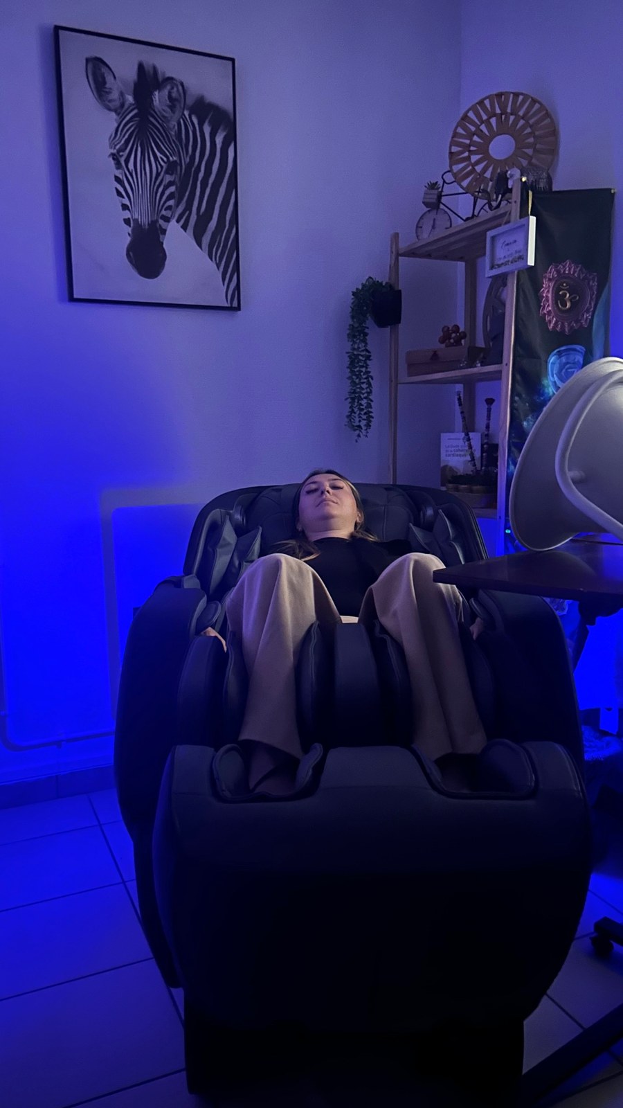 Une visiteuse au repos dans le fauteuil zéro gravité, dans la lumière bleue de l’espace